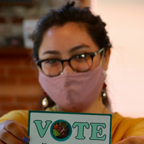 Closeup image of a woman holding white and green card reading, 