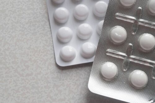 A close-up photo of blister packs containing round medication tablets.